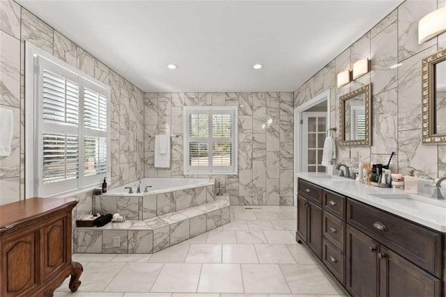 669 Dixon Dr, Gainesville, GA 30501 - bathroom featuring tile walls, healthy amount of natural light, a bath, double vanity, and marble look tiles