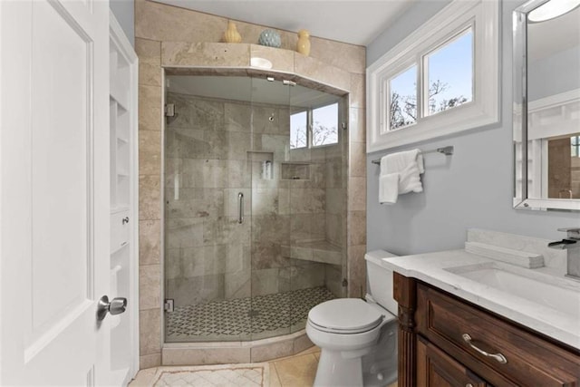 full bath with toilet, a stall shower, tile patterned floors, and vanity