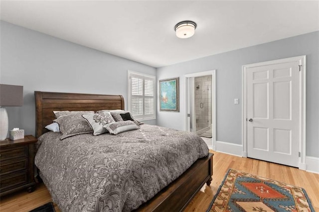 bedroom featuring ensuite bath, baseboards, and wood finished floors