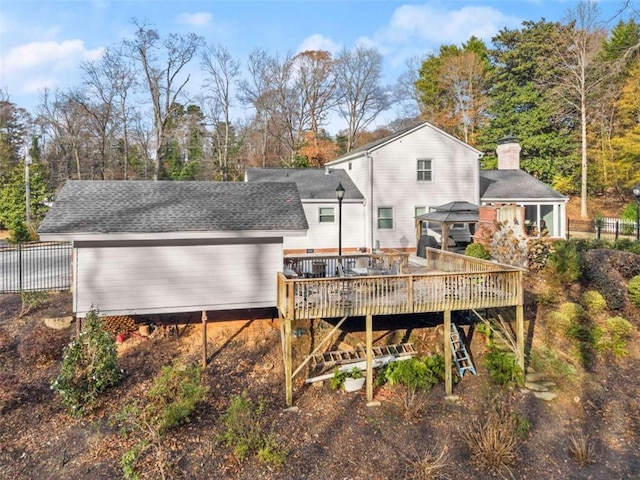 669 Dixon Dr, Gainesville, GA 30501 - rear view of property featuring a wooden deck, a gazebo, a chimney, a shingled roof, and view of scattered trees
