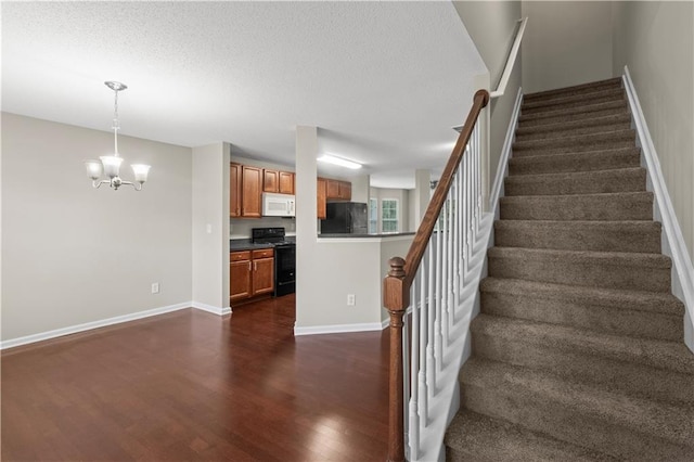 stairway featuring dark hardwood / wood-style flooring and an inviting chandelier