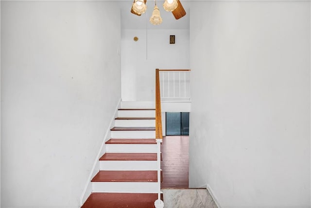 stairway with hardwood / wood-style flooring and ceiling fan