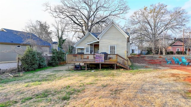 rear view of house with a lawn and a deck