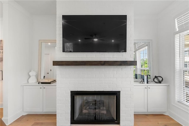 interior details featuring a fireplace, wood finished floors, baseboards, and ornamental molding