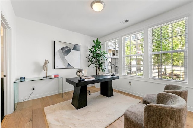 office featuring light wood-type flooring, visible vents, and baseboards