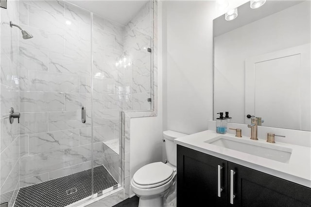 bathroom featuring vanity, toilet, and a shower stall