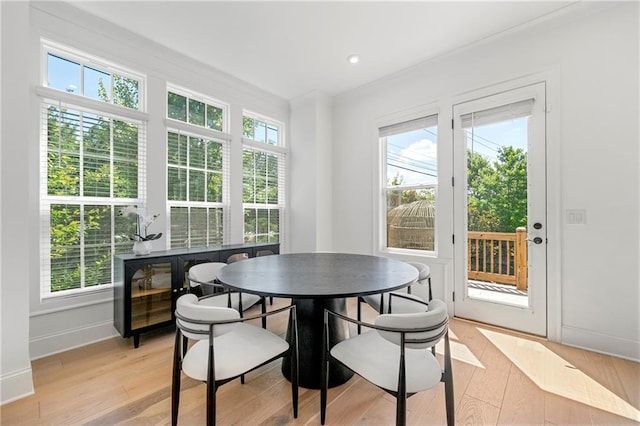 dining room featuring light wood-style floors, baseboards, and a wealth of natural light