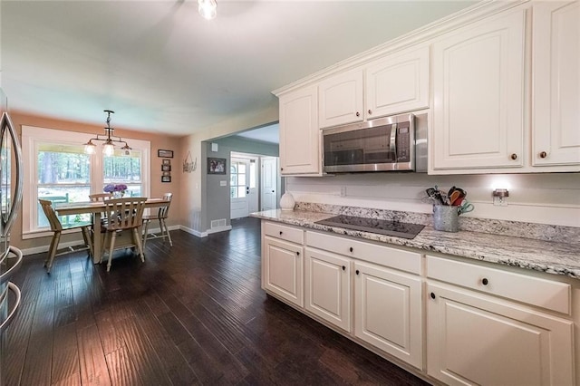 527 Gaddis Rd, Canton, GA 30115 - kitchen featuring stainless steel microwave, black electric stovetop, white cabinetry, and dark wood-style flooring