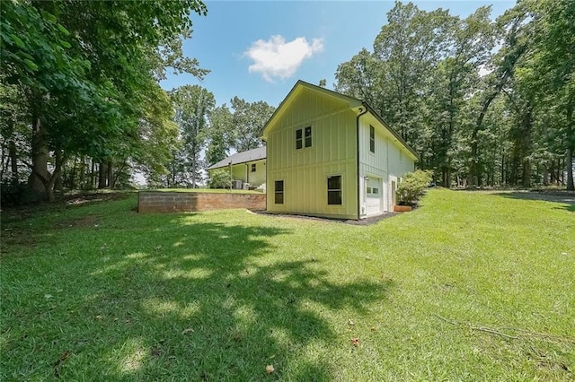 527 Gaddis Rd, Canton, GA 30115 - view of side of home with board and batten siding, a garage, and a yard