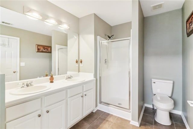 bathroom with vanity, a shower with shower door, toilet, and tile patterned flooring