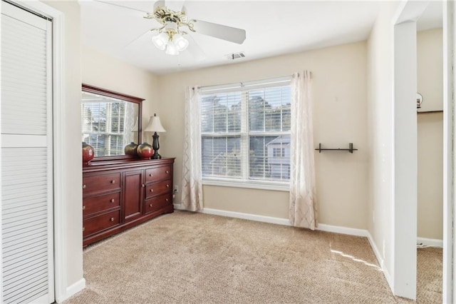 bedroom with a closet, ceiling fan, and light carpet