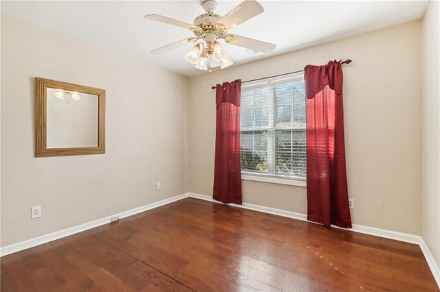 spare room with ceiling fan and dark hardwood / wood-style flooring