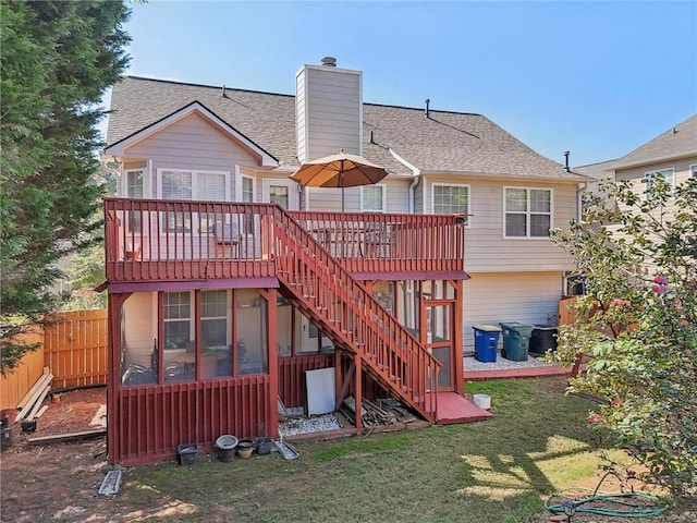 rear view of house featuring a deck and a lawn