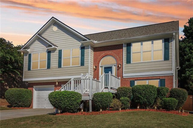 bi-level home featuring a yard and a garage