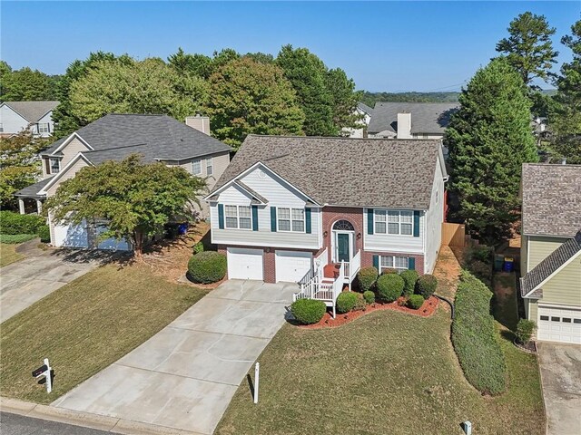 bi-level home with a front yard and a garage