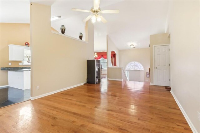 unfurnished living room with light hardwood / wood-style floors, high vaulted ceiling, and ceiling fan