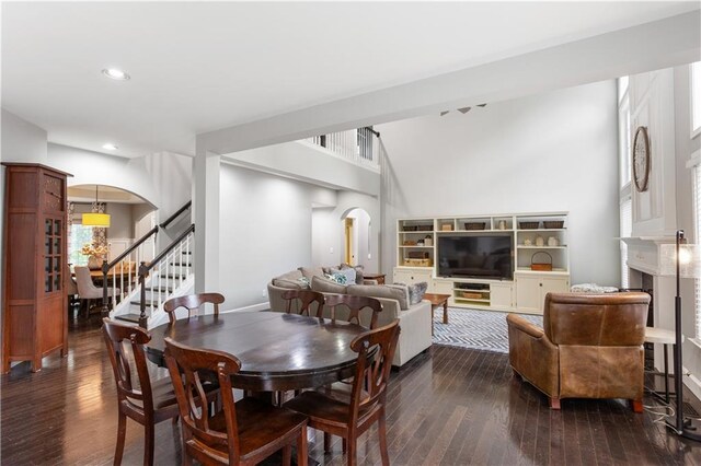 141 Ennisbrook Dr SE, Smyrna, GA 30082 - dining area featuring arched walkways, dark wood-style floors, stairway, recessed lighting, and a fireplace
