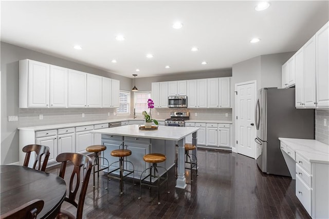 141 Ennisbrook Dr SE, Smyrna, GA 30082 - kitchen with stainless steel appliances, decorative backsplash, white cabinets, a kitchen island, and a kitchen breakfast bar