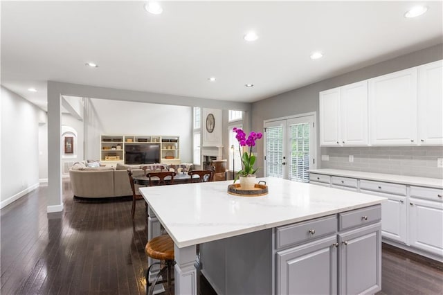 141 Ennisbrook Dr SE, Smyrna, GA 30082 - kitchen with a kitchen island, white cabinets, a fireplace, dark wood-style floors, and recessed lighting