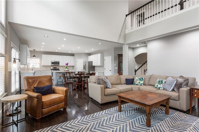 141 Ennisbrook Dr SE, Smyrna, GA 30082 - living room with dark wood-type flooring, a high ceiling, recessed lighting, and stairway