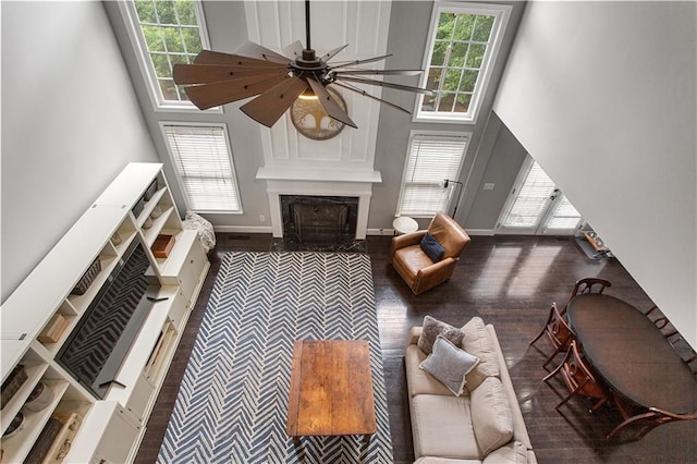 141 Ennisbrook Dr SE, Smyrna, GA 30082 - living room featuring a high end fireplace, a towering ceiling, a ceiling fan, wood finished floors, and baseboards