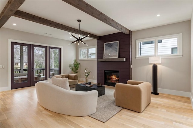 living room featuring a large fireplace, baseboards, and wood finished floors