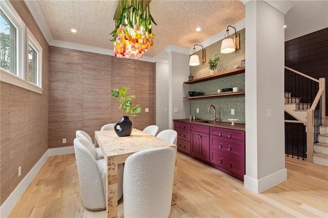 dining space with baseboards, stairway, and light wood-style floors