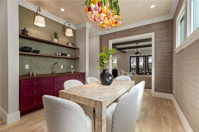 dining area with light wood-style flooring, baseboards, and french doors