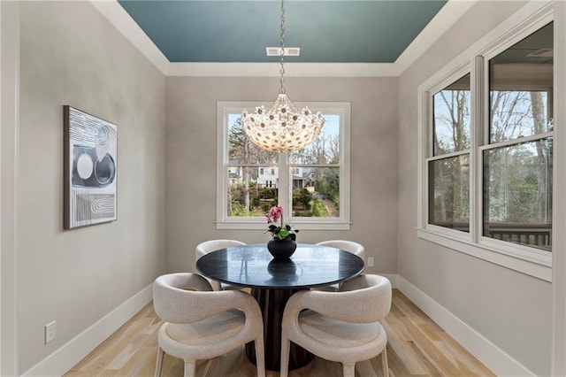 dining room with light wood-style floors, baseboards, and an inviting chandelier