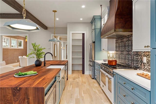 kitchen featuring premium range hood, butcher block countertops, a sink, backsplash, and high end appliances