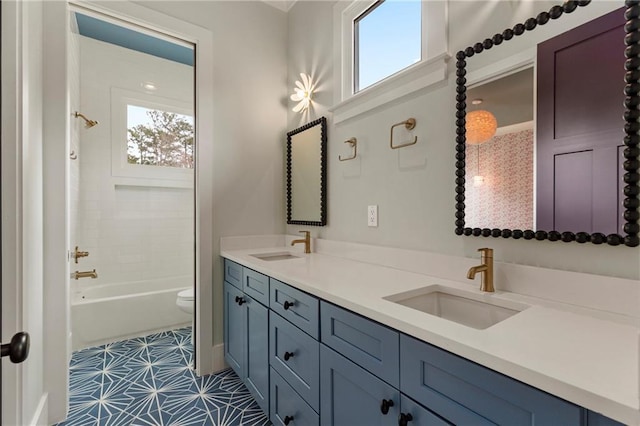 full bath featuring double vanity, toilet, a sink, and bathing tub / shower combination