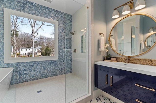 bathroom with plenty of natural light, visible vents, walk in shower, and vanity