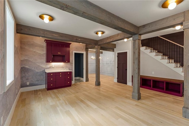 662 Timm Valley Rd NE, Atlanta, GA 30305 - interior space featuring light wood-type flooring, reddish brown cabinets, beam ceiling, and ornate columns
