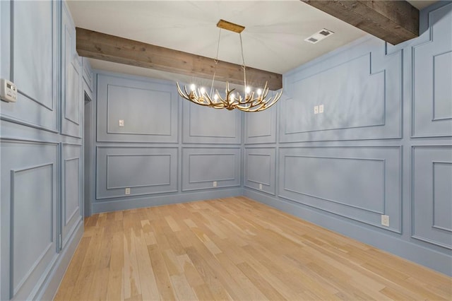 unfurnished dining area with visible vents, a decorative wall, a chandelier, light wood-type flooring, and beamed ceiling