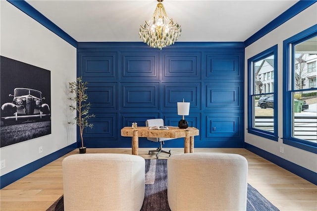 dining space featuring light wood-style floors, a notable chandelier, and baseboards