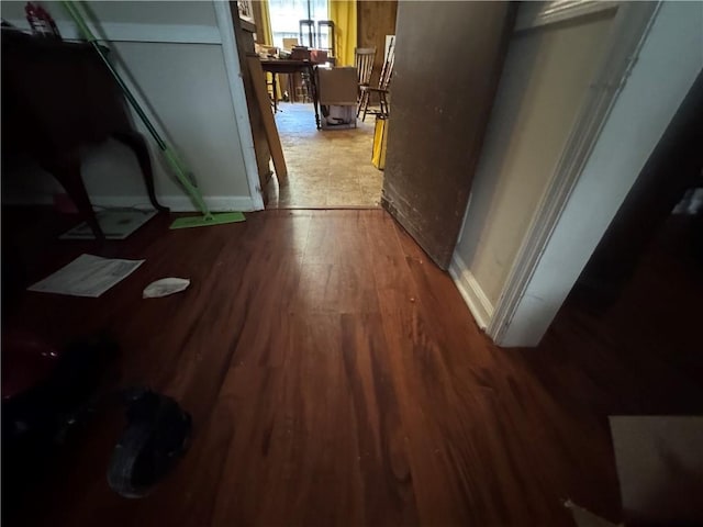 hallway with wood finished floors and baseboards