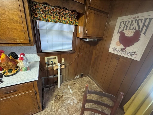 laundry area with cabinet space, washer hookup, and wood walls