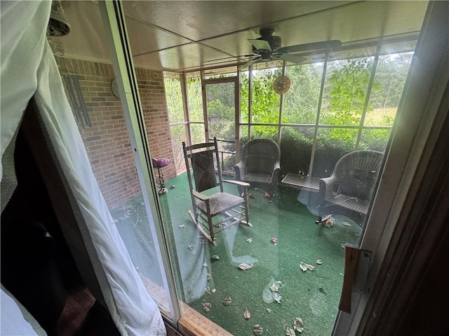 sunroom featuring a ceiling fan