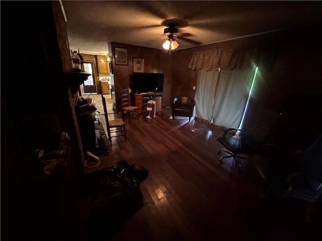 living area with wood finished floors and a ceiling fan