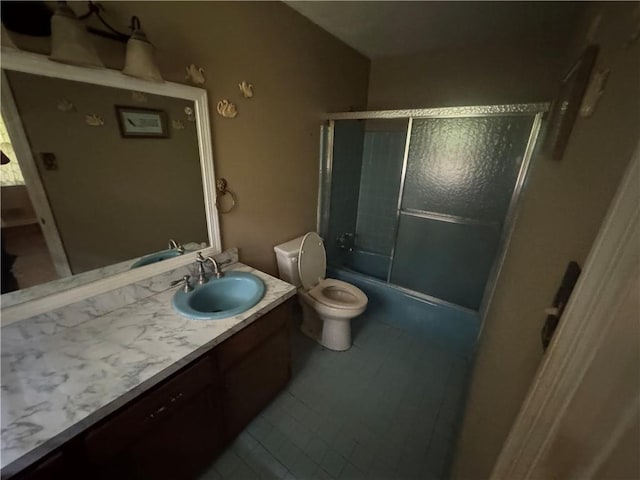full bath with vanity, tile patterned floors, toilet, and shower / bath combination with glass door