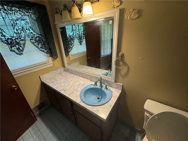 bathroom with tile patterned floors, vanity, toilet, and baseboards