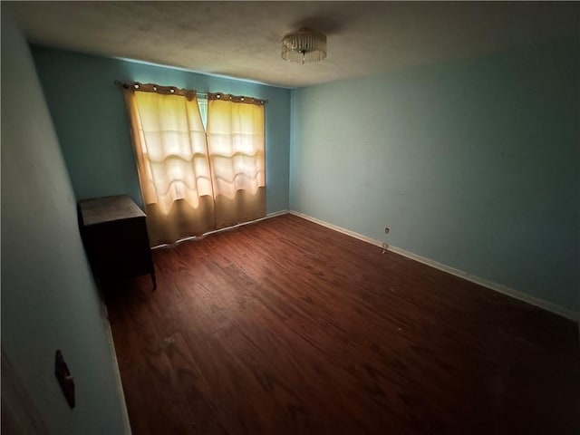 unfurnished room with wood finished floors and baseboards