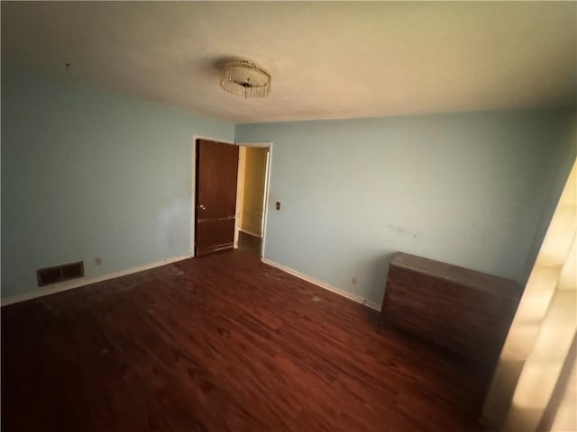 spare room with wood finished floors and baseboards