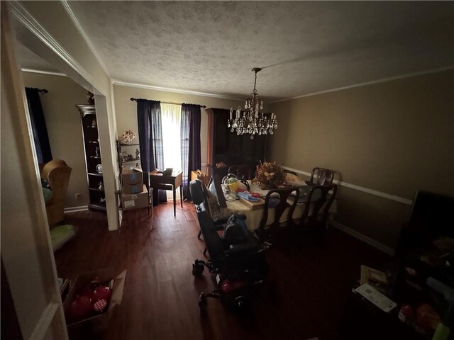 dining room with a chandelier, dark wood-style flooring, a textured ceiling, and ornamental molding