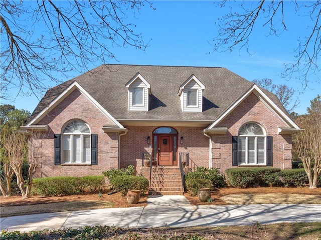 view of front of property featuring brick siding and a shingled roof