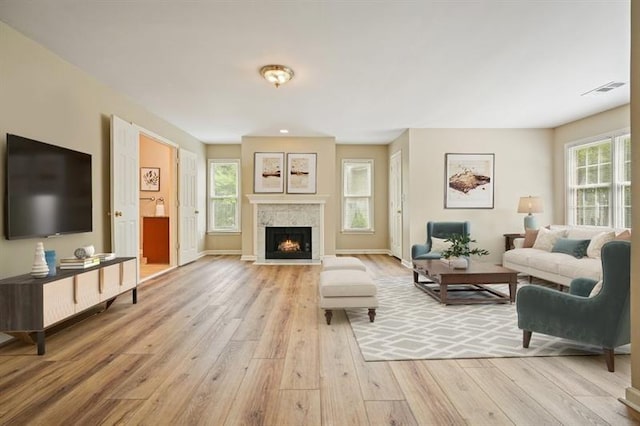3130 Crestmont Way NW, Kennesaw, GA 30152 - living area featuring light wood-type flooring, healthy amount of natural light, a warm lit fireplace, and baseboards