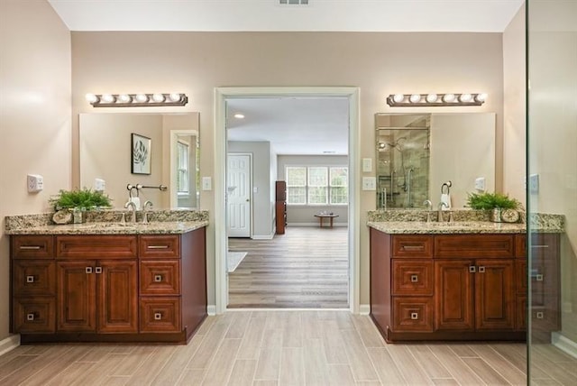3130 Crestmont Way NW, Kennesaw, GA 30152 - bathroom with baseboards, a shower stall, wood finish floors, and two vanities