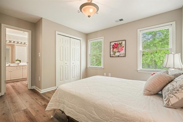 3130 Crestmont Way NW, Kennesaw, GA 30152 - bedroom featuring wood finished floors, a closet, baseboards, and connected bathroom