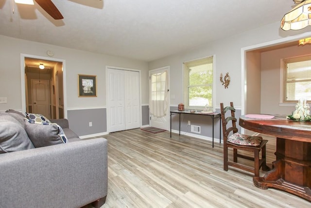 living room with light hardwood / wood-style floors and ceiling fan