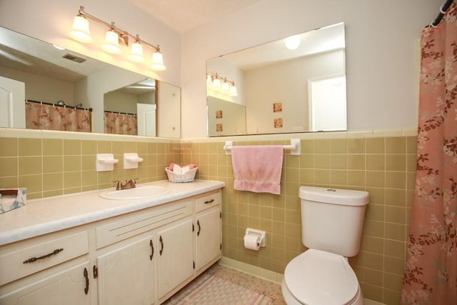 bathroom featuring tile walls, toilet, vanity, and a shower with shower curtain